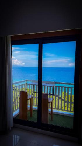 a room with a view of the ocean from a balcony at Aqua Horizon Beachside Condo I Signature Art Suites in Dauis