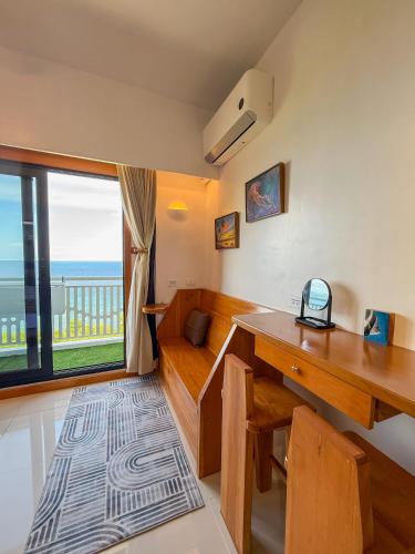 a home office with a desk and a view of the ocean at Aqua Horizon Beachside Condo I Signature Art Suites in Dauis
