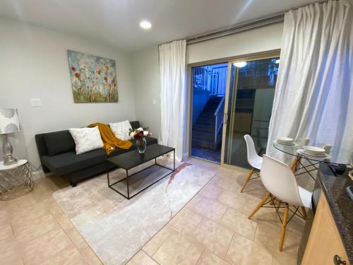 a living room with a couch and a table at Bright 1-Bedroom Garden Suite, Sleeps 4, Near Downtown & YVR in Vancouver