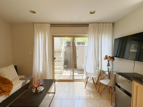 a living room with a couch and a table at Bright 1-Bedroom Garden Suite, Sleeps 4, Near Downtown & YVR in Vancouver