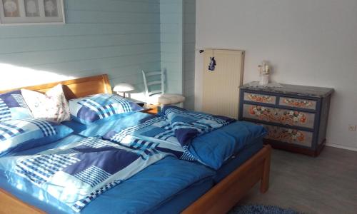 a bedroom with a bed with blue sheets and a dresser at Haus Sagl in Nauders