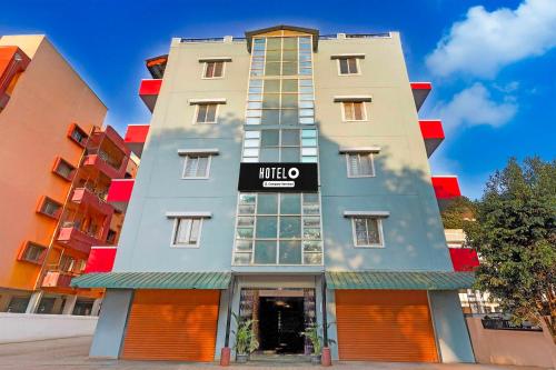 a tall building with a sign that reads mitzo at Hotel O Electronic City in Kammasandra