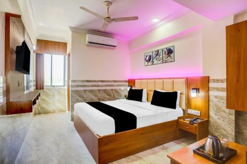 a bedroom with a bed and a tv in a room at Hotel O Ahmedabad Airport in Ahmedabad