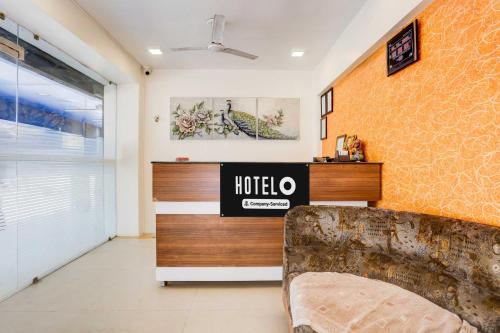 a hotel room with a couch and a wall at Hotel O Ahmedabad Airport in Ahmedabad