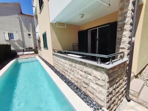 einem Pool vor einem Haus mit einem Gebäude in der Unterkunft Villa Veronika in Brodarica