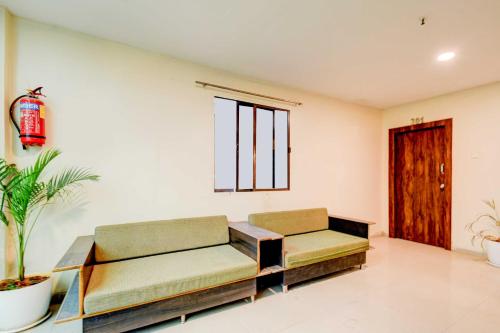 a living room with two couches and a window at Hotel O Isckon Temple in Hyderabad