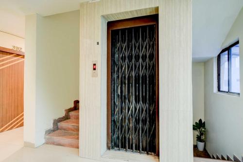 a black door in a hallway with stairs at Hotel O Isckon Temple in Hyderabad