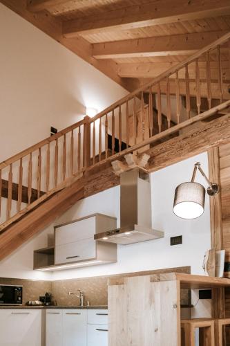 a kitchen with a wooden staircase and a sink at Chalet Mornà in San Martino in Badia