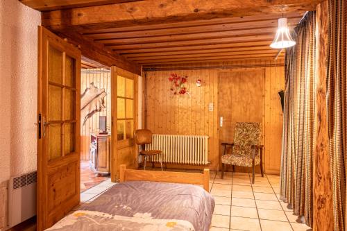 une chambre avec un lit et une chaise dans une pièce dans l'établissement Appartement Atypique, à La Bresse