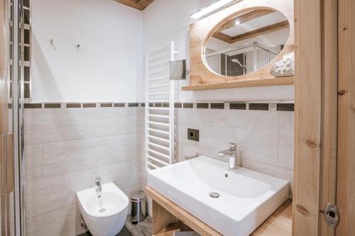 a bathroom with a white sink and a mirror at Chalet Mornà in San Martino in Badia