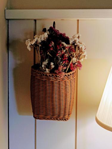 a basket of flowers is hanging on a wall at Casa da Beira Rio in Marco de Canavezes