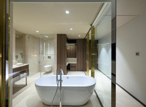 a bathroom with a white tub in a room at Merlis Hotel Coimbatore in Coimbatore