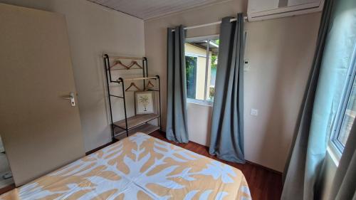 a bedroom with a bed and a window at Fare Tetua in Punaauia