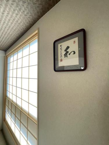 a picture hanging on a wall next to a window at 大同ガーデンホテル京都 in Kyoto
