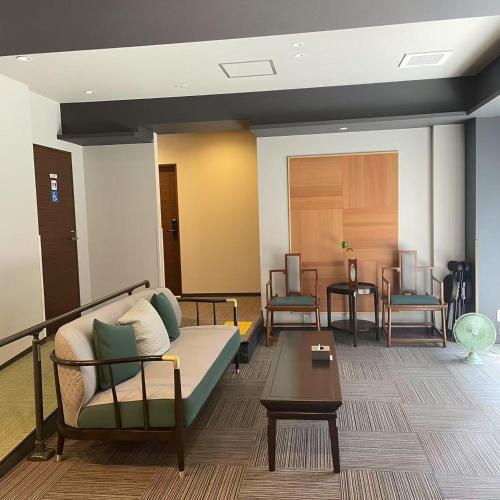 a waiting room with a couch and two chairs at 大同ガーデンホテル京都 in Kyoto
