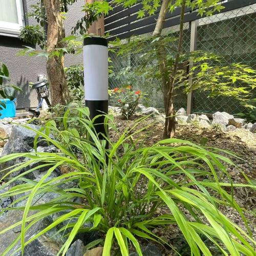 a plant in a garden with a black and white pole at 大同ガーデンホテル京都 in Kyoto