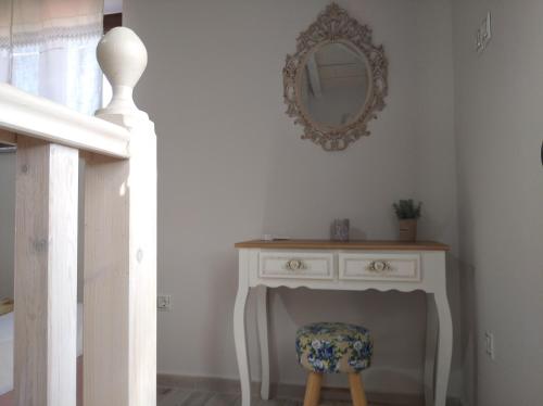 a white table with a chair and a mirror at Paliokaliva Home in Roussopoúlion