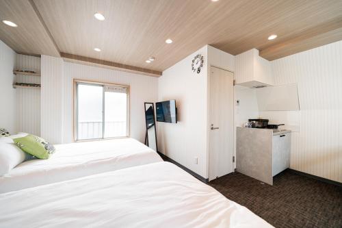 a bedroom with two beds and a window at Sunshine Inn 456 - Economic APT in Tokyo Tranquil Block, with Direct Access to Ginza & Akihabara in Tokyo