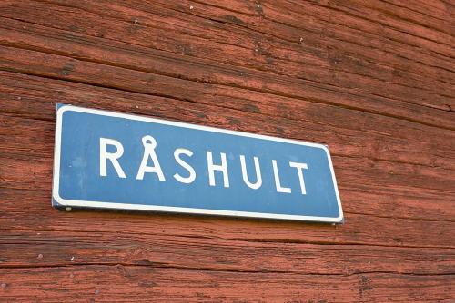 a sign on the side of a wooden wall at Råshults Gård in Vimmerby