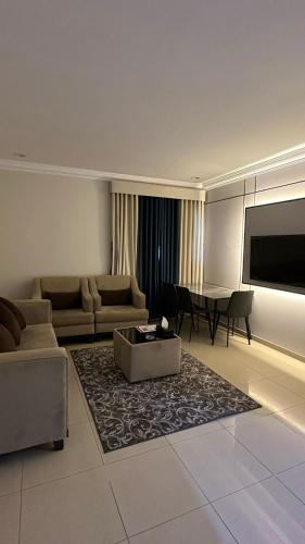 a living room with a couch and a table at راحتي للشقق المخدومة in Taif