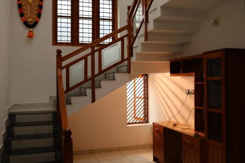a staircase in a room with a stair case at Salora by Mohanam Comfort Homes in Kazhakuttam