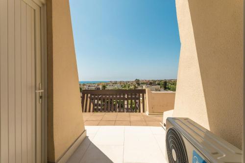 Une porte ouverte s'ouvre sur un balcon avec vue. dans l'établissement l'instant Bleu Port nature, au Cap d'Agde