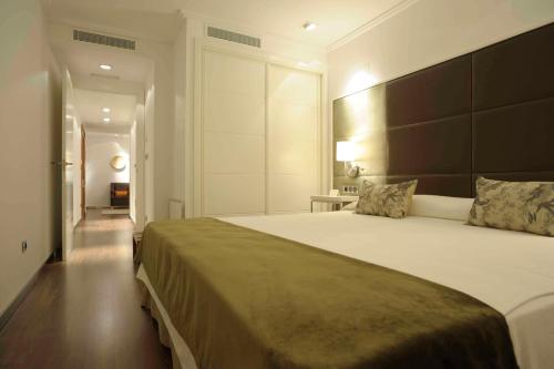 a bedroom with a large bed with a large headboard at San Ramón del Somontano in Barbastro