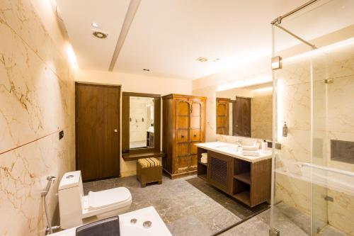 a bathroom with a toilet and a sink and a shower at Alaya Stays Jeevantara by ELIVAAS in Udaipur