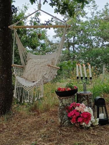 a hammock in a garden with flowers and candles at Casa da Beira Rio in Marco de Canavezes