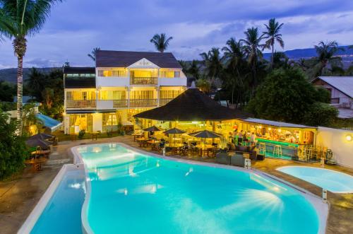 a hotel with a large swimming pool in front of a building at Le Nautile Beachfront in Saint-Gilles les Bains