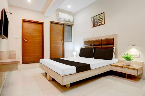瓜廖尔Hotel O Jiwaji Chowk Lashkar的房间里有一张大床的卧室