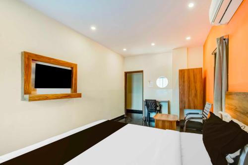 a bedroom with a bed and a tv on the wall at Hotel O Dilsukhnagar Metro Station in Hyderabad