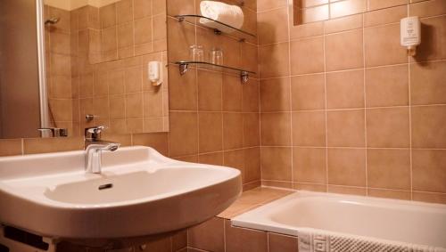 a bathroom with a sink and a tub at Hotel Seeblick in Döbriach