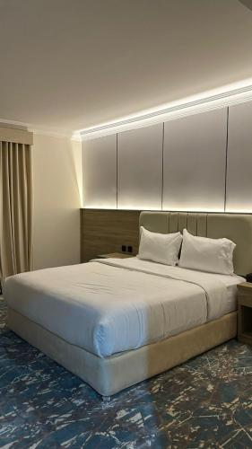 a bedroom with a large bed with white sheets and pillows at راحتي للشقق المخدومة in Taif
