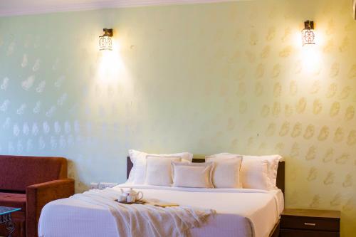a bedroom with a bed and two lights on the wall at Alaya Stays Jeevantara by ELIVAAS in Udaipur