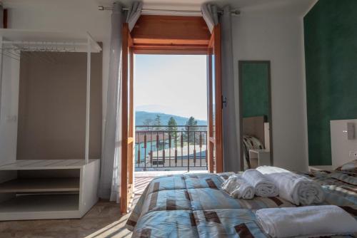a bedroom with a bed and a large window at Il Risveglio del Cavaliere Casa Vacanza in Gioia dei Marsi
