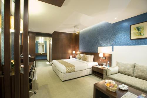 pokój hotelowy z łóżkiem i kanapą w obiekcie Enrise by Sayaji Bhopal w mieście Bhopal