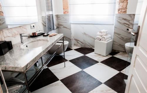 a bathroom with a sink and a black and white checkered floor at Hotel Villa Fanny in Cagliari