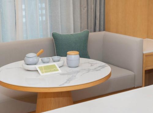 a living room with a table and a couch at All Seasons Hotel Chongxi Road, Shanghai International Tourism Hotel - Near Shanghai Disney in Shanghai