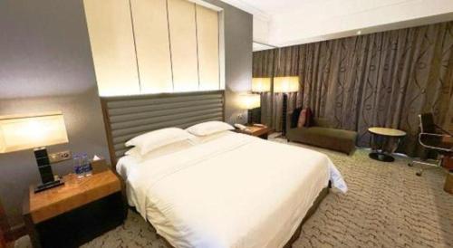 a bedroom with a large white bed in a hotel room at King Century Hotel in Zhongshan