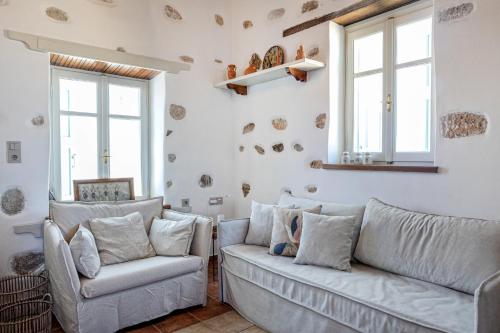 a living room with two couches and two windows at Castro Nido in Astypalaia Town
