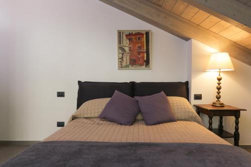 een slaapkamer met een bed met 2 paarse kussens bij Italian Lakes Apartment 14009 in Lesa