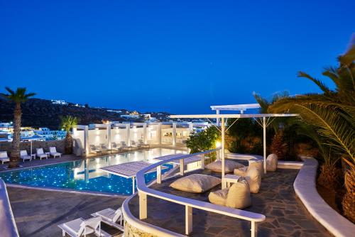a hotel with a swimming pool at night at Palladium Hotel in Platis Yialos Mykonos