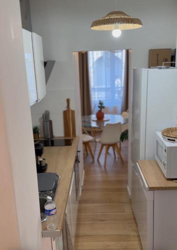 a kitchen with a white refrigerator and a table at Appart Béziers Cocooning in Béziers
