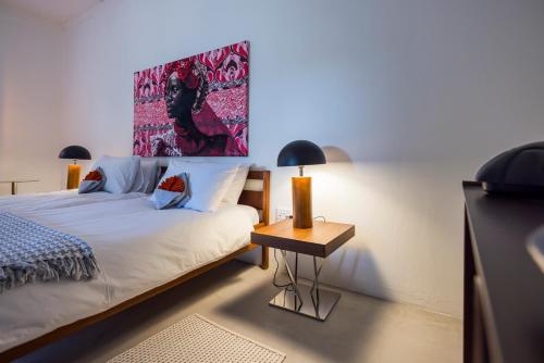 a bedroom with a bed and a table with a lamp at Ohorongo Safari Lodge in Kamanjab