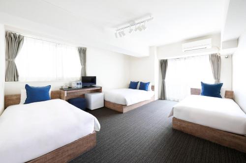 a hotel room with two beds and a television at montan HAKATA in Fukuoka