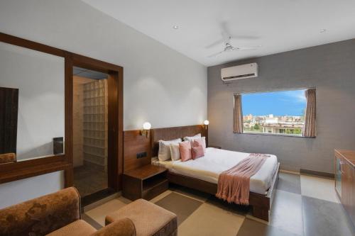 a hotel room with a bed and a window at Alaya Stays Jeevantara by ELIVAAS in Udaipur