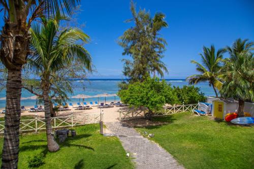 a beach with palm trees and the ocean at Le Nautile Beachfront in Saint-Gilles les Bains