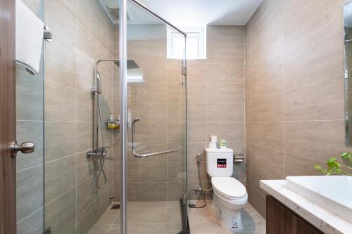 a bathroom with a toilet and a glass shower at Jade house Nguyễn Thị Minh Khai in Ho Chi Minh City