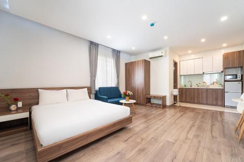 a bedroom with a white bed and a blue chair at Jade house Nguyễn Thị Minh Khai in Ho Chi Minh City